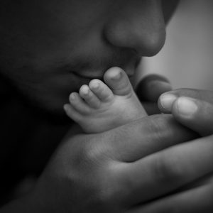 Father kissing the small foot of his baby